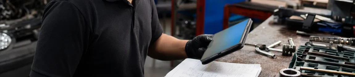 Glossário siglas carro francês: técnico consulta anotações técnicas em oficina